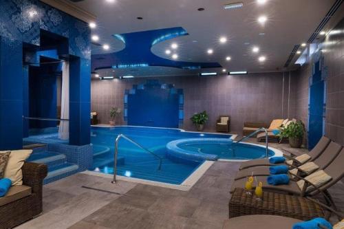 ein großer Pool in einem Zimmer mit einem blauen Zimmer in der Unterkunft Golden Ball Club in Győr