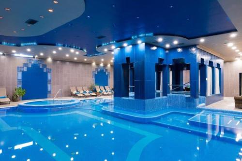 a large blue swimming pool in a hotel room at Golden Ball Club in Győr