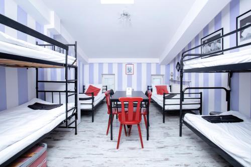 a room with a table and chairs and bunk beds at AB Hostel in Warsaw