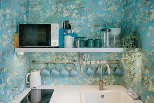 a kitchen with a sink and a microwave at Chase Apartments-Boutiquehotel Style II in Würzburg