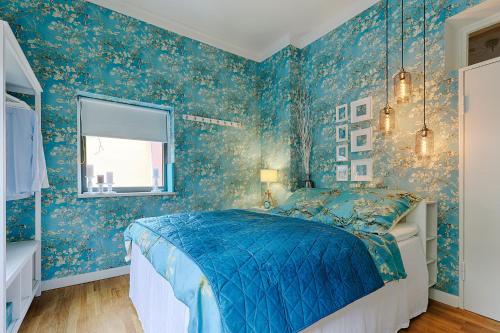 a bedroom with blue floral wallpaper and a bed at Chase Apartments-Boutiquehotel Style II in Würzburg