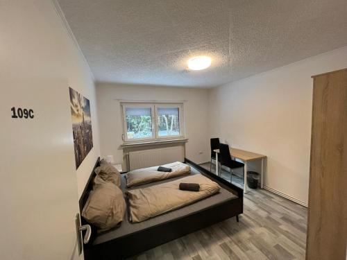 a bedroom with a bed and a desk and a window at OELTALAS Immobilien GmbH in Oldenburg