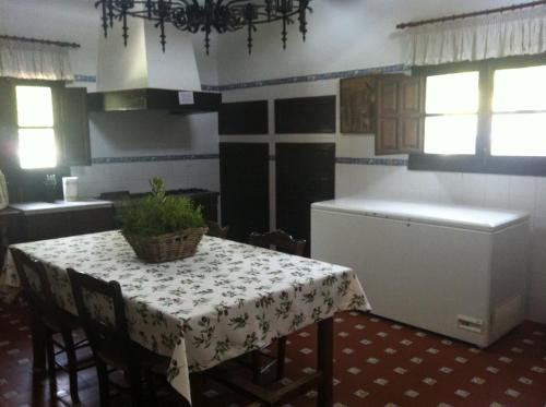 a kitchen with a table with a table cloth on it at Cortijo La Priorita in Córdoba