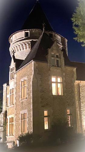 a large stone building with a clock tower on top at Château de Bouesse en Berry in Bouesse