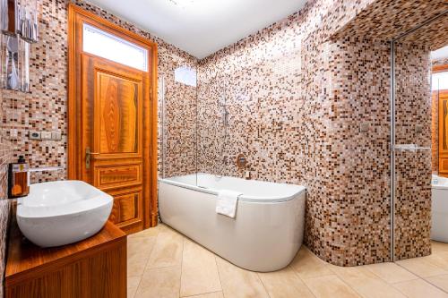 a bathroom with a tub and a toilet and a sink at Malostranská Residence in Prague