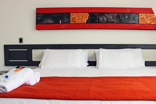 a bedroom with a large bed with a red blanket at Hotel Guaitipan Plaza in Pitalito