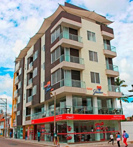 a tall building with people walking in front of it at Hotel Guaitipan Plaza in Pitalito