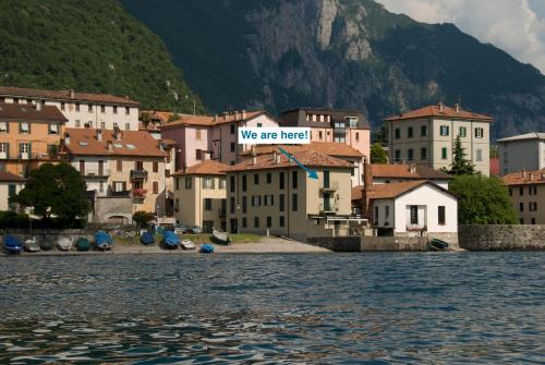 una città sull'acqua con un cartello che dice "siamo qui" di Mamma Ciccia Holiday Home - Sunset Balcony ad Abbadia Lariana