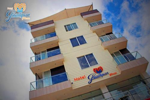 a tall yellow building with a hotel sign on it at Hotel Guaitipan Plaza in Pitalito