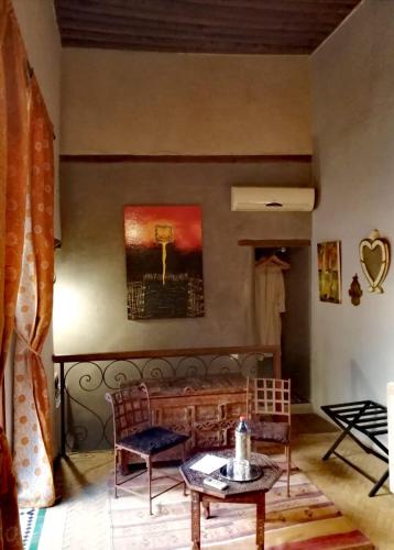 a living room with a couch and a table and a chair at Les Bains de Fez Tara in Fès