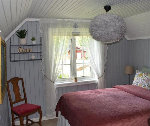 a bedroom with a bed and a chair and a window at Cozy Country House in Spydeberg