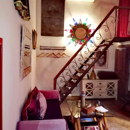 a living room with a staircase with a purple couch at Les Bains de Fez Tara in Fès