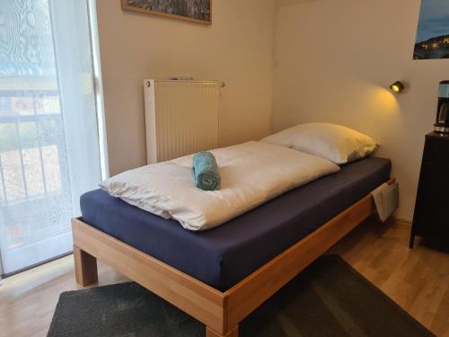 łóżko z niebieską poduszką na górze w obiekcie Lichtdurchflutetes Zimmer - Marienberg w mieście Waldbüttelbrunn