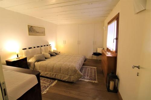 Un dormitorio con una cama grande y una ventana en San Marco charming apartment with canal view, en Venecia
