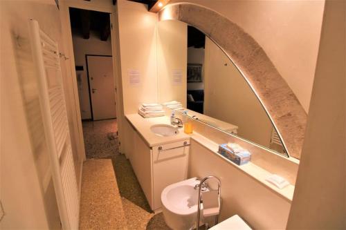 y baño con lavabo y espejo. en San Marco charming apartment with canal view, en Venecia