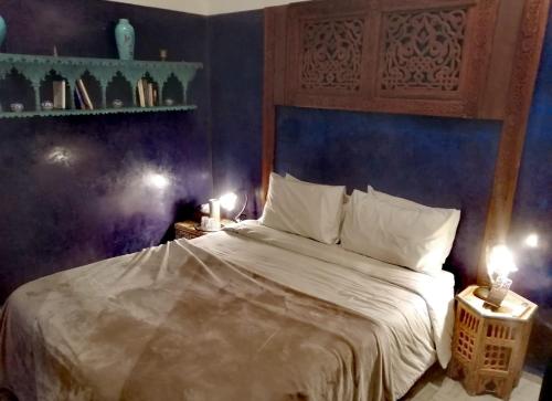 a bedroom with a large bed with two lights on it at Les Bains de Fez Tara in Fès