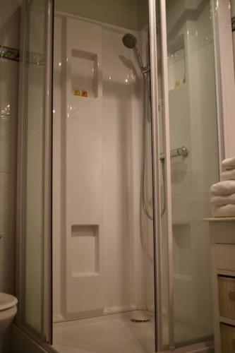 une douche avec une porte vitrée dans une salle de bain dans l'établissement Cottage calme et reposant en pleine nature, à Reilhac