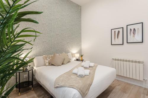 a bedroom with a white bed with towels on it at BNBHolder Ponzano & Chamberi II in Madrid