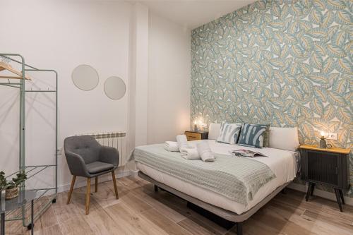 1 dormitorio con 1 cama y 1 silla en BNBHolder Ponzano & Chamberi III, en Madrid