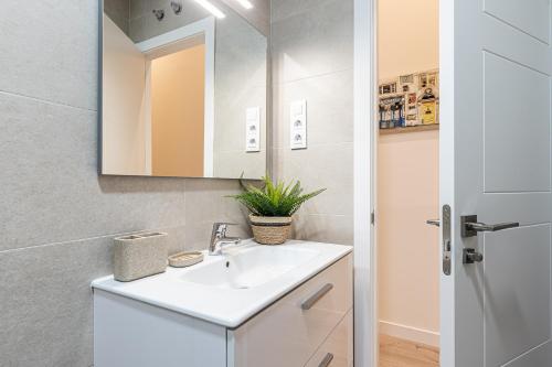 La salle de bains est pourvue d'un lavabo blanc et d'un miroir. dans l'établissement BNBHolder Ponzano & Chamberi III, à Madrid