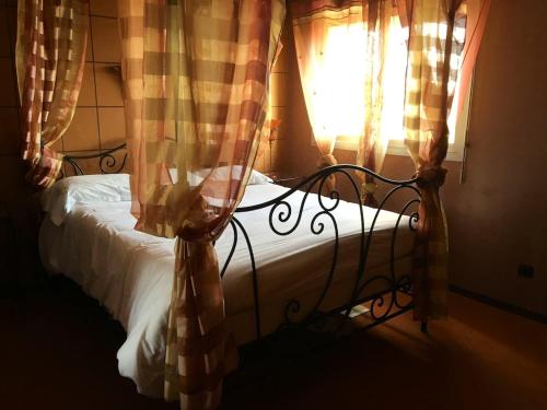a bed in a bedroom with a window with curtains at Villa charmante à Nalliers avec piscine in Nalliers