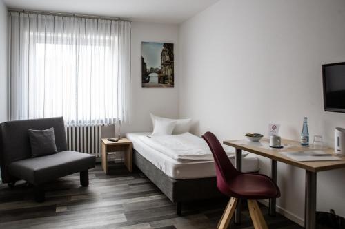 a bedroom with a bed and a desk and a chair at Europa-Haus-Bocholt - Bett & Bike in Bocholt