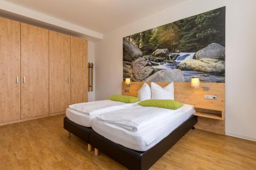 1 dormitorio con 1 cama con una pintura en la pared en 3 Raum Ferienwohnung Premium, en Schulenberg im Oberharz