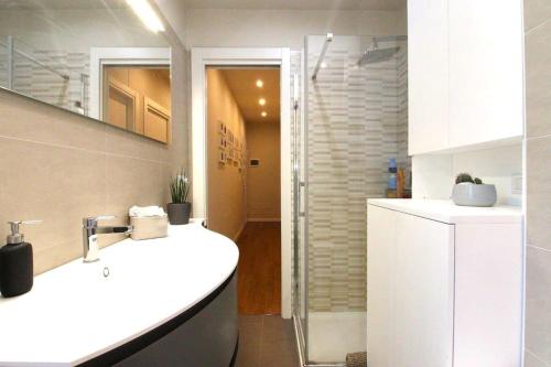 a bathroom with a white sink and a shower at Sant'Orsola Malpighi Apartment in Bologna
