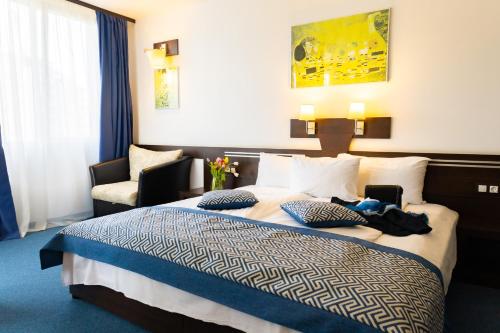 um quarto de hotel com uma cama e uma cadeira em Grami Hotel Sofia em Sófia