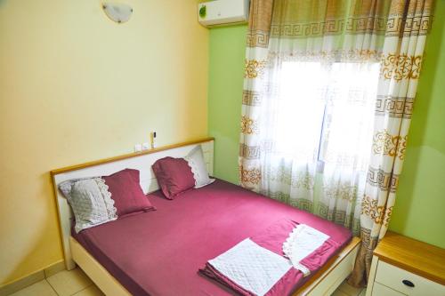 - un petit lit dans une chambre avec fenêtre dans l'établissement Three rooms Appartment Bieyem assi, à Yaoundé