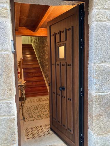 a wooden door leading into a hallway with stairs at Casa Marinera "Tu casa de Baiona" in Baiona