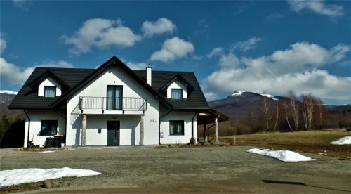 una casa blanca con techo negro en Wetlina Poza Trasą, en Wetlina