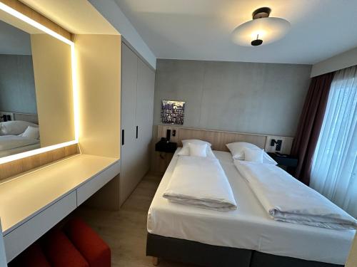 a hotel room with a bed and a mirror at Apartment-Hotel Hamburg Mitte in Hamburg