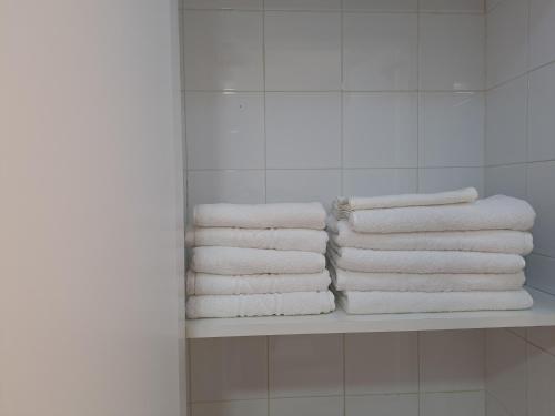 einen Stapel Handtücher auf einem Regal im Bad in der Unterkunft Suite familiar Portalet in Benaguacil