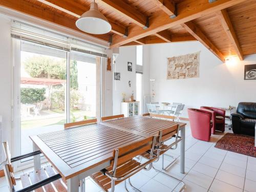 un salon avec une table et des chaises en bois dans l'établissement Villa spacieuse à Gruissan, 4 chambres, jardin privé, clim, proche plage, idéal familles/amis - FR-1-409A-18, à Gruissan