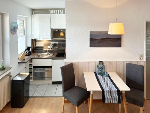 una cucina con tavolo e sedie in una stanza di Haus Diana *Ferienwohnung Kniepsand* a Wittdün
