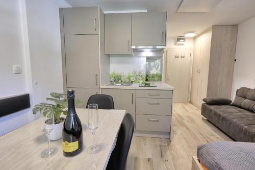 - une cuisine et un salon avec une table et deux verres à vin dans l'établissement Studio Pika, à Kranjska Gora