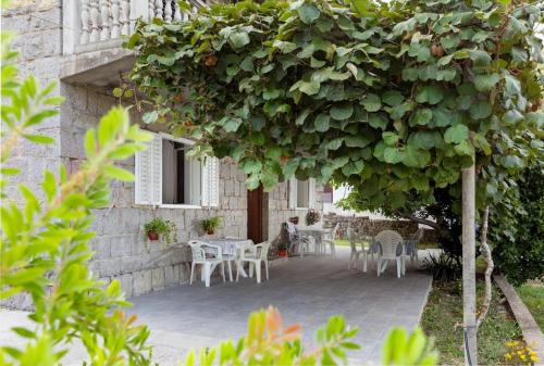 a garden with a table and chairs under a tree at Private En Suite Room Matkovic. Kotor Bay in Bijela