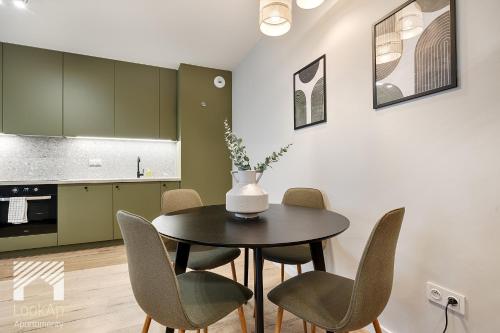 a kitchen and dining room with a table and chairs at Fuzja II by LookAp in Łódź