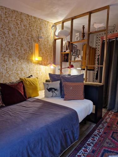 a bedroom with a bed with colorful pillows on it at Sauveur le Sculpteur in Talence