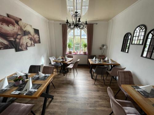 ein Restaurant mit Holztischen und -stühlen und einem Fenster in der Unterkunft Suite Appartements Da Giovanni in Gladenbach