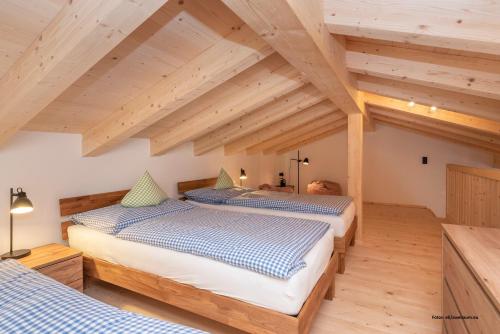 two beds in a room with wooden ceilings at TUX MOUNTAIN Apart in Tux