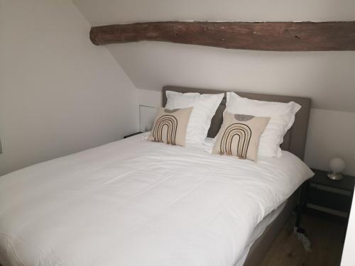 a white bed with two pillows on top of it at petit logement Crecy la chapelle in Crécy-la-Chapelle