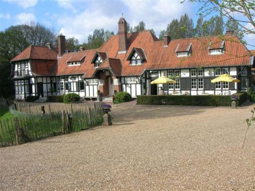 a large house with yellow umbrellas in front of it at Hotel Kasteelhof 'T Hooghe in Ypres