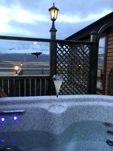 a jacuzzi tub on a deck with an airplane at Eyjar Fishing Lodge in Breiðdalsvík
