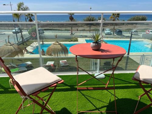 een tafel en stoelen op een balkon met een zwembad bij Vista Azul Duna 2 by Spain2home in Torrox