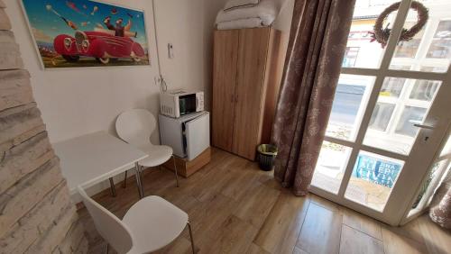 a small room with a table and chairs and a microwave at MP Center Magánszállás in Miskolc
