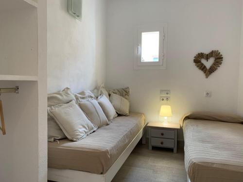 a small bedroom with two beds and a window at Copacabana 21 in Es Pujols