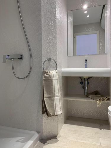 ein Bad mit einer Dusche, einem Waschbecken und einem Spiegel in der Unterkunft Copacabana 21 in Es Pujols
