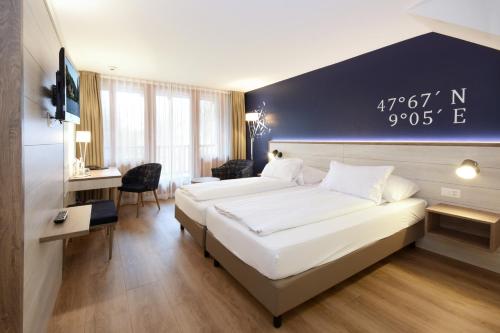 ein Hotelzimmer mit 2 Betten und einem Schreibtisch in der Unterkunft Seehotel Schiff in Mannenbach